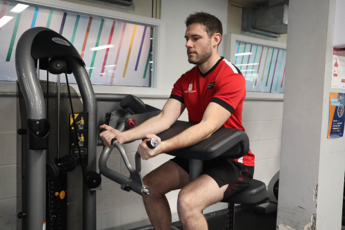 Staff member Paul enjoys the new equipment at the Indoor Sports Centre at the University of Bristol. Paul is pictured doing arm curls on one of the new weights machines.